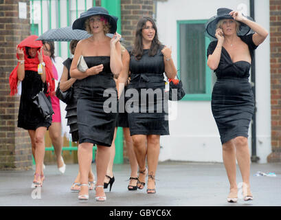 Les amateurs de course prennent la relève alors que la pluie commence à tomber après la Ladies Day au festival d'août de l'hippodrome de Brighton. Banque D'Images