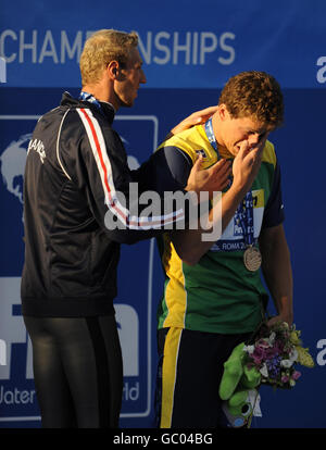 Le brésilien Cesar Cielo Filho pleure lors de la cérémonie de remise des médailles avec Alain Bernard, médaillé d'argent français (à gauche), après avoir remporté la finale Freestyle de 100 m masculin lors des Championnats du monde de natation de la FINA à Rome, en Italie. Banque D'Images