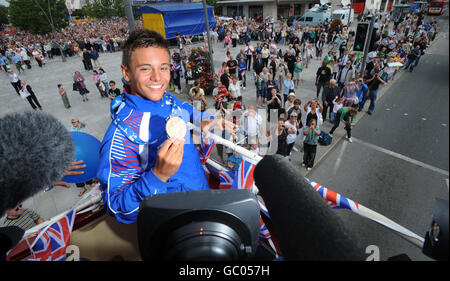 Tom Daley montre sa médaille d'or, qu'il a gagnée aux championnats du monde de plongée à Rome, lors d'une visite en bus à toit ouvert de Plymouth. Banque D'Images