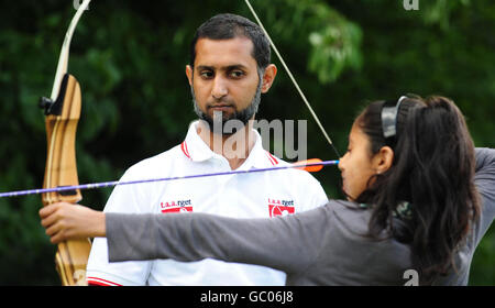 Le professeur de tir à l'arc Sabir Makda regarde comme sa fille Zahra Makda prend fin lors d'un sport dans la communauté qui s'est tenue au Mirfield Showground, West Yorkshire. Banque D'Images