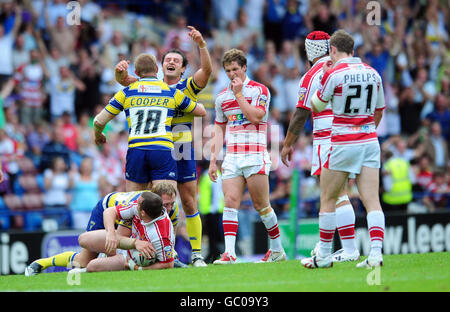 Michael Cooper et Jon Clarke de Warrington célèbrent lors du dernier coup de sifflet, tandis que les joueurs de Wigan sont abattus lors du match semi-final de la coupe du défi Carnegie au Stobart Stadium, Widnes. Banque D'Images