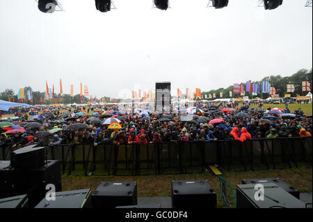 Vue générale de l'arène principale depuis la scène en plein air tandis que les festivaliers se réfugient à l'abri de la pluie pendant le festival Womad à Charlton Park, Wiltshire. Banque D'Images