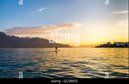 Une pagaie simple boarder sur le lac de Genève en Suisse au coucher du soleil Banque D'Images