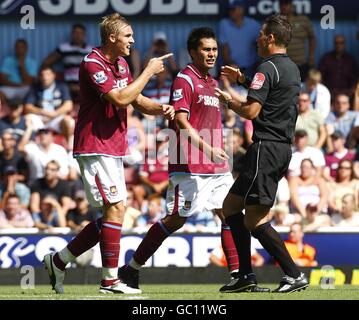 Jack Collison (à gauche) et Luis Jimenez (au centre) de West Ham United disputent avec l'arbitre Mark Clattenburg (à droite). Banque D'Images