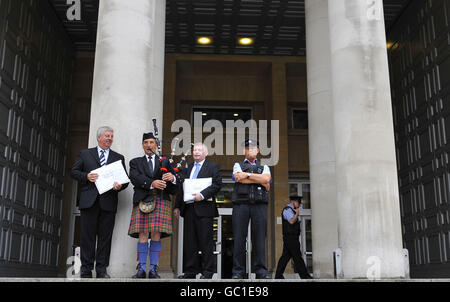 (À partir de la gauche) Angus MacMillan, président de Storas Uibhist, joueur de cornemuse James MacKay et Angus Campbell, président de la force de travail de la chaîne Hebrides à l'extérieur du ministère de la Défense à Londres, Envoi de lettres au MOD et au gouvernement pour lutter contre les plans visant à réduire un champ d'essais d'armes dans les Hébrides extérieures, ce qui entraînera des pertes d'emplois. Banque D'Images