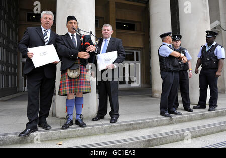 (À partir de la gauche) Angus MacMillan, président de Storas Uibhist, joueur de cornemuse James MacKay et Angus Campbell, président de la force de travail de la chaîne Hebrides à l'extérieur du ministère de la Défense à Londres, Envoi de lettres au MOD et au gouvernement pour lutter contre les plans visant à réduire un champ d'essais d'armes dans les Hébrides extérieures, ce qui entraînera des pertes d'emplois. Banque D'Images