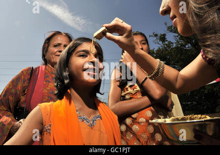 Un tilak est appliqué à un pèlerin au festival Shree Krishna Janmashtami au Bhaktivedanta Manor à Watford. Banque D'Images