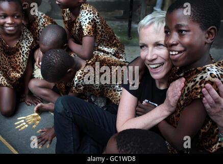 Les enfants du chœur africain des enfants aident la chanteuse Annie Lennox à dévoiler un mémorial à Nelson Mandela, où la pierre porte l'inscription de la Fondation 46664 de l'association caritative Nelson Mandela sur le SIDA, à l'extérieur des chambres de ville d'Édimbourg. Banque D'Images