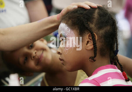 Les sœurs Annabel, 4 ans, (à droite) et Aimee Gasanaas, 5 ans, de Londres, ont peint leur visage, l'une des nombreuses activités proposées, pendant la journée d'évasion annuelle de l'organisme de bienfaisance pour enfants Starlight - pour aider à égayer la vie des enfants gravement et en phase terminale - à Popham Airfield, dans le Hampshire. Banque D'Images