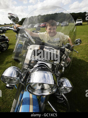 James Johnston, 10 ans, de Chatham, est assis sur une moto Harley Davidson, l'une des nombreuses activités proposées, pendant la journée d'évasion annuelle de la charité pour enfants Starlight - pour aider à éclairer la vie des enfants gravement et en phase terminale - à l'aérodrome de Popham, dans le Hampshire. Banque D'Images