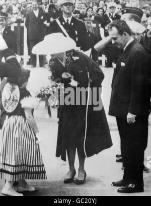 Grace Kelly recevant un bouquet d'une petite fille en costume Monagasque à son arrivée à Monte Carlo de New York pour son mariage au Prince Rainier de Monaco. Banque D'Images