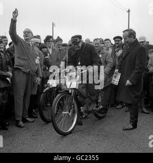 John Surtees (debout, à droite), qui a été champion du monde sur deux roues et qui est actuellement champion du monde sur quatre roues, apprécie quelques commentaires très clairs avec Rider V.F. Smith (prénom inconnu) de Barnes Common, avant de partir de Tattenham Corner, Epsom, Surrey, dans la 29e Pioneer Run à Brighton. M. Smith était à la tête d'un quadrant solo de 1904 396 cc. Banque D'Images