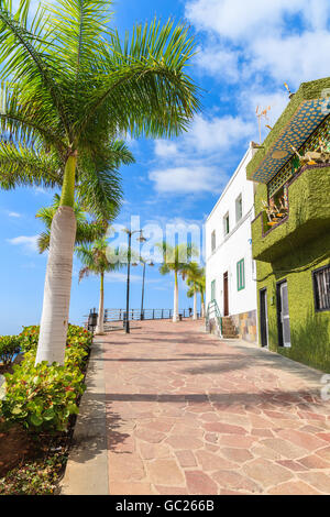 Palmiers sur la promenade dans la ville d'Alcala avec architecture typique des Canaries sur la côte de Tenerife, Canaries, Espagne Banque D'Images