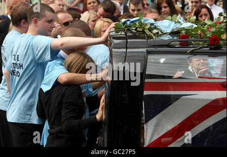 Les boureurs se réconfortent les uns les autres dans les rues de Wootton Bassett, dans le Wiltshire, tandis que les corps du caporal James Fullarton, du sergent Simon Valentine, de Fusillier Simon Annis et de Fusilier Louis carter, tous du 2e Bataillon Royal Regiment of Fusiliers, sont conduits à travers la ville après leur rapatriement à la RAF Lyneham. Banque D'Images