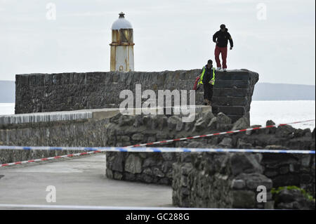 Boy a balayé la mer à Porthcawl pier Banque D'Images