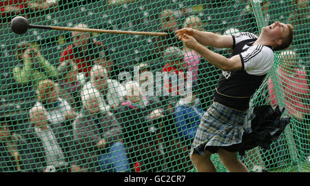 Un concurrent lance un marteau pendant les Highland Games à Braemar, en Écosse. Des milliers de gens du coin, de touristes et d'amateurs royaux se réunissent chaque année pour assister aux événements traditionnels des Highland Games, y compris le lancer du caber et un remorqueur de guerre. Banque D'Images