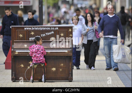 Ashanti James, 4 ans, de Fishmares, joue un piano solitaire dans le centre de Broadmead, le principal quartier commerçant de Bristol, qui fait partie d'une installation d'art intitulée « Play Me » par l'artiste de Bristol Luke Jerram. Banque D'Images