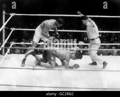 Boxe - World Heavyweight Title - Jack Dempsey v Luis Firpo - Polo Grounds - New York.Luis Firpo essayant de se lever après avoir été envoyé sur la toile par Jack Dempsey quelques secondes avant le coup final dans le second tour. Banque D'Images