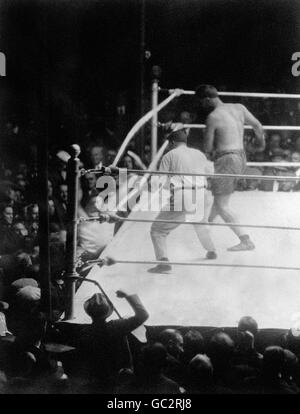 Luis Firpo frappe Jack Dempsey dans les cordes de la presse où il a atterri sur une machine à écrire de reporter&#8217;s. Dempsey est revenu sur le ring et a arrêté Firpo avec deux knockDown au second tour. Banque D'Images