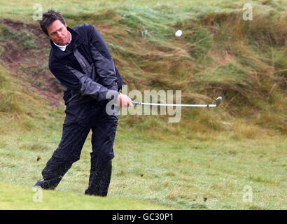 Acteur Hugh Grant pendant une journée d'entraînement sous la pluie au parcours de golf de Kingsbarns, avant le championnat Alfred Dunhill Links qui commence jeudi. Banque D'Images