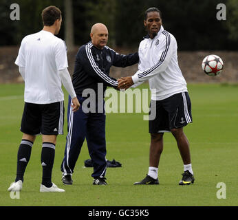 Didier Drogba, de Chelsea, serre la main avec l'entraîneur assistant Ray Wilkins (au centre) pendant la séance d'entraînement à Cobham Training Ground, Surrey. Banque D'Images