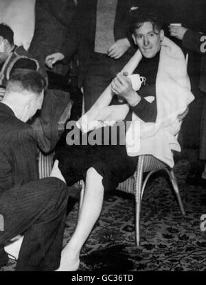 Le Matelot de 1re classe Malcolm McKinnon, survivant du traversier submergé Starnraer à Larne MV Princess Victoria, a ses pieds massés pour les réchauffer à l'atterrissage en Irlande du Nord après son épreuve dans les mers de sable (samedi) Banque D'Images