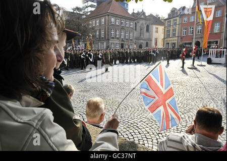 Une femme allemande porte le drapeau de l'Union alors que plus de 500 soldats de la 20e Brigade blindée - la Fiste de fer, marquent leur retour des opérations en Irak, L'Afghanistan et le Kosovo en défilant dans leur ville de garnison de Paderborn devant des centaines de spectateurs de la communauté allemande locale et des familles et amis des soldats. Banque D'Images