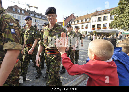 Un petit enfant donne à un soldat un « haut cinq » après avoir « chuté » de la parade et les soldats se dirigent pour un service d'église alors que plus de 500 soldats de la 20e Brigade blindée - le poing de fer, marquent leur retour des opérations en Irak, L'Afghanistan et le Kosovo en défilant dans leur ville de garnison de Paderborn devant des centaines de spectateurs de la communauté allemande locale et des familles et amis des soldats. Banque D'Images