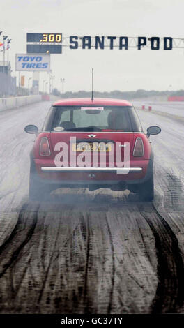 Un mini-pilote se prépare à courir contre une police britannique Subaru Impreza WRX, une voiture de police américaine, lors de « Beat the Heat » à Santa Pod Race Way, Wellingborough, Northamptonshire. Banque D'Images