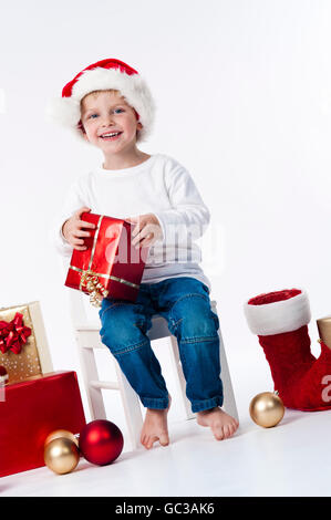 Garçon avec chapeau de Père Noël et des cadeaux de Noël Banque D'Images