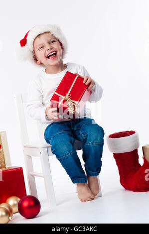 Garçon avec chapeau de Père Noël et des cadeaux de Noël Banque D'Images