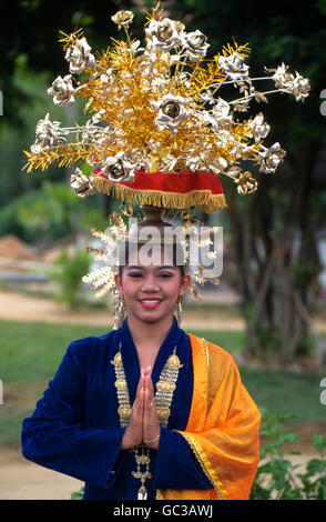 Une jeune femme malaisienne en costume traditionnel avec un énorme hat Banque D'Images