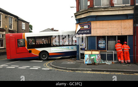 Les agents de recherche et de sauvetage se penchent sur les bookmakers de William Hill à Dukinfield, dans le Grand Manchester, après qu'un autobus a laboudé à travers le mur du bâtiment, tuant un homme. Banque D'Images