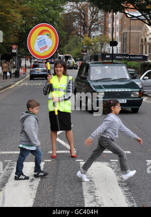 La présentatrice de la télévision Lorraine Kelly arrête la circulation avec les écoliers au passage piétonnier d'Abbey Road, à Londres, lors du lancement des prix Lollipop personne de l'année 2009. Banque D'Images