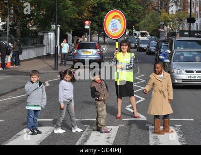 La présentatrice de la télévision Lorraine Kelly arrête la circulation avec les écoliers au passage piétonnier d'Abbey Road, à Londres, lors du lancement des prix Lollipop personne de l'année 2009. Banque D'Images