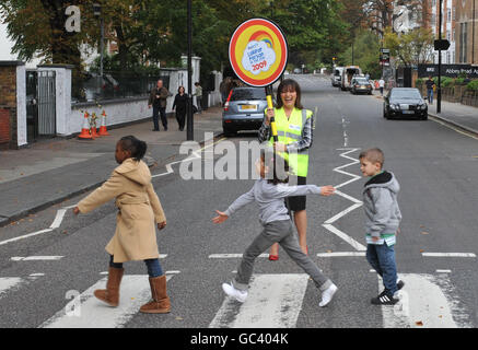 La présentatrice de la télévision Lorraine Kelly arrête la circulation avec les écoliers au passage piétonnier d'Abbey Road, à Londres, lors du lancement des prix Lollipop personne de l'année 2009. Banque D'Images