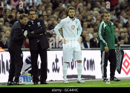 David Beckham (au centre) en Angleterre avec le gérant Fabio Capello (2e à partir de la gauche), sur la ligne de contact Banque D'Images