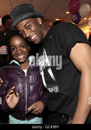 Oritse Williams du groupe JLS rencontre Rachel Rasaq, 11 ans, de Bethnal Green, lorsqu'il visite le magasin T-Mobile d'Oxford Street, Londres, avec d'autres membres du groupe pour marquer le lancement du Nokia 5800 'livré avec la musique' en chrome. Banque D'Images