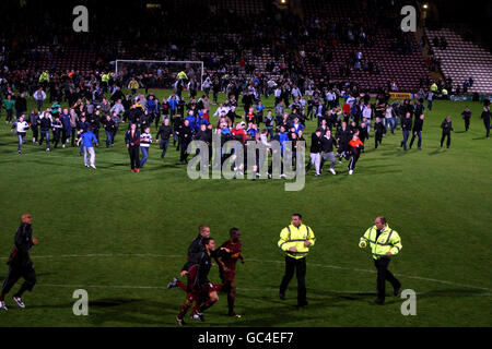 Les fans de Bradford City envahissent le terrain après avoir vu leur équipe gagner la pénalité de tir alors que leur Manager Stuart McCall (au centre, de retour à la caméra) tente d'empêcher les fans d'atteindre les joueurs Banque D'Images