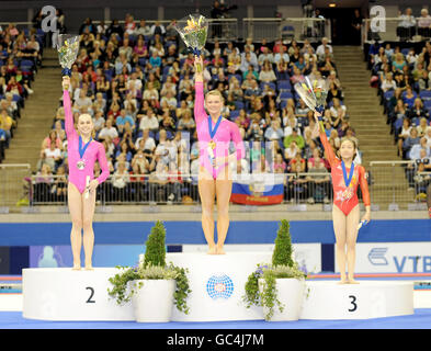 Bridget Sloan (au centre) des États-Unis célèbre sa médaille d'or avec Rebecca Bross (à gauche, argent) des États-Unis et Koko Tsurumi (à droite, bronze) du Japon lors de la finale All Round des femmes lors des championnats du monde de gymnastique à l'O2 Arena à Londres. Banque D'Images