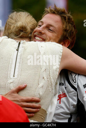 Le champion du monde de Formule 1 Jenson Button est embrassé par Jodie Kidd alors qu'il prend les gagnants de la compétition pour une balade en Mercedes sportive lors d'une apparition au centre commercial Bluewater de Greenhithe, Kent. Banque D'Images