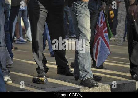 Un manifestant de la Ligue de défense galloise détient un drapeau de l'Union tandis que son groupe est tenu à l'écart des manifestants antifascistes par la police lors d'une manifestation près de Castle Square, à Swansea, au pays de Galles. Banque D'Images