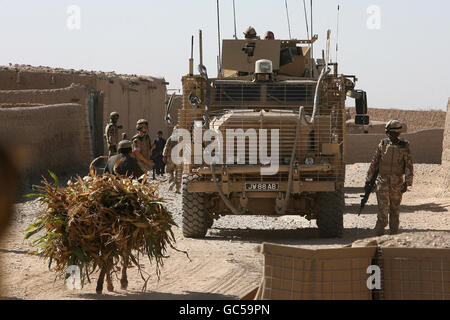 Des soldats du 1er Bataillon, Grenadier Guards, regardent comme un fermier afghan et son âne passe sur un chemin à Basharan, en Afghanistan. Banque D'Images