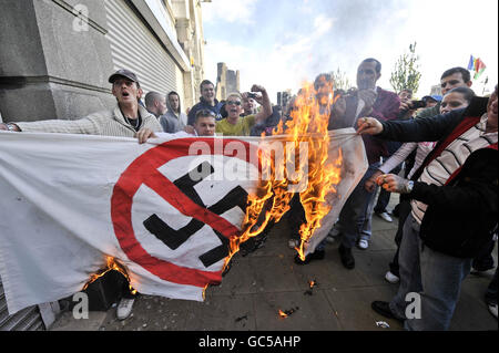 Les manifestants de la Ligue de défense galloise ont brûlé un drapeau anti-nazi lors d'une manifestation à Swansea, au pays de Galles. Banque D'Images