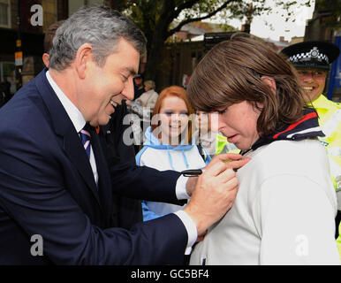 RETRANSMITED CORRECTION DU NOM DU GARÇON À LA LUMIÈRE DE NOUVELLES INFORMATIONS le premier ministre Gordon Brown signe le chandail de Jamie Pallach, 17 ans, de South Elmsall, Alors qu'il rencontre des acheteurs lors d'une promenade dans le centre de Wakefield City aujourd'hui après sa visite à l'hôtel de ville où il a été informé des initiatives de lutte contre le crime à Wakefield. Banque D'Images