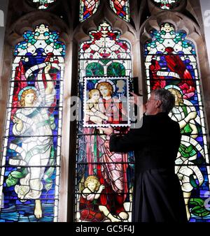 Le révérend Neil Spencer est titulaire d'un timbre soufflé devant la fenêtre en vitrail Henry Holiday de l'église St Michael d'Ormesby, Norfolk, qui est en vente aujourd'hui sur un timbre de première classe du numéro du timbre de Noël de Royal Mail. Banque D'Images