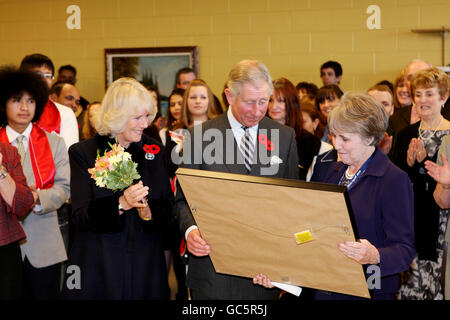 Le Prince de Galles et la duchesse de Cornwall présentent un certificat de service de longue durée à Bridget Foster (à droite) à l'Association pour les nouveaux Canadiens, lors d'une visite à St. John's, Terre-Neuve, Canada. Banque D'Images