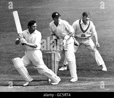 Cricket - Championnats du comté 1971 - Middlesex v Notinghamshire - troisième jour - terrain de cricket Lords.Le batteur J. B. Bolus (Notinghshire) tire Harry Latchman (Middlesex) pour 6 comme le gardien de cricket de John Murray le regarde. Banque D'Images