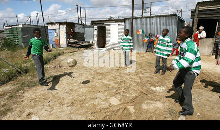 Les enfants jouent au football dans le canton de Wallacadene, Cape Town, Donecarney kits de football celtique remis par des volontaires de Loreto High School Beaufort à Dublin, qui participent au bâtiment Blitz de Niall Mellon Township Trust, dans la ville sud-africaine. Banque D'Images