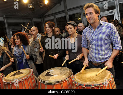 Ben Fogle, présentateur de télévision, apprend à se faire le tambour avec les membres du public à Covent Garden, dans le centre de Londres, dans le cadre de l'American Express réaliser le potentiel de la campagne. Banque D'Images